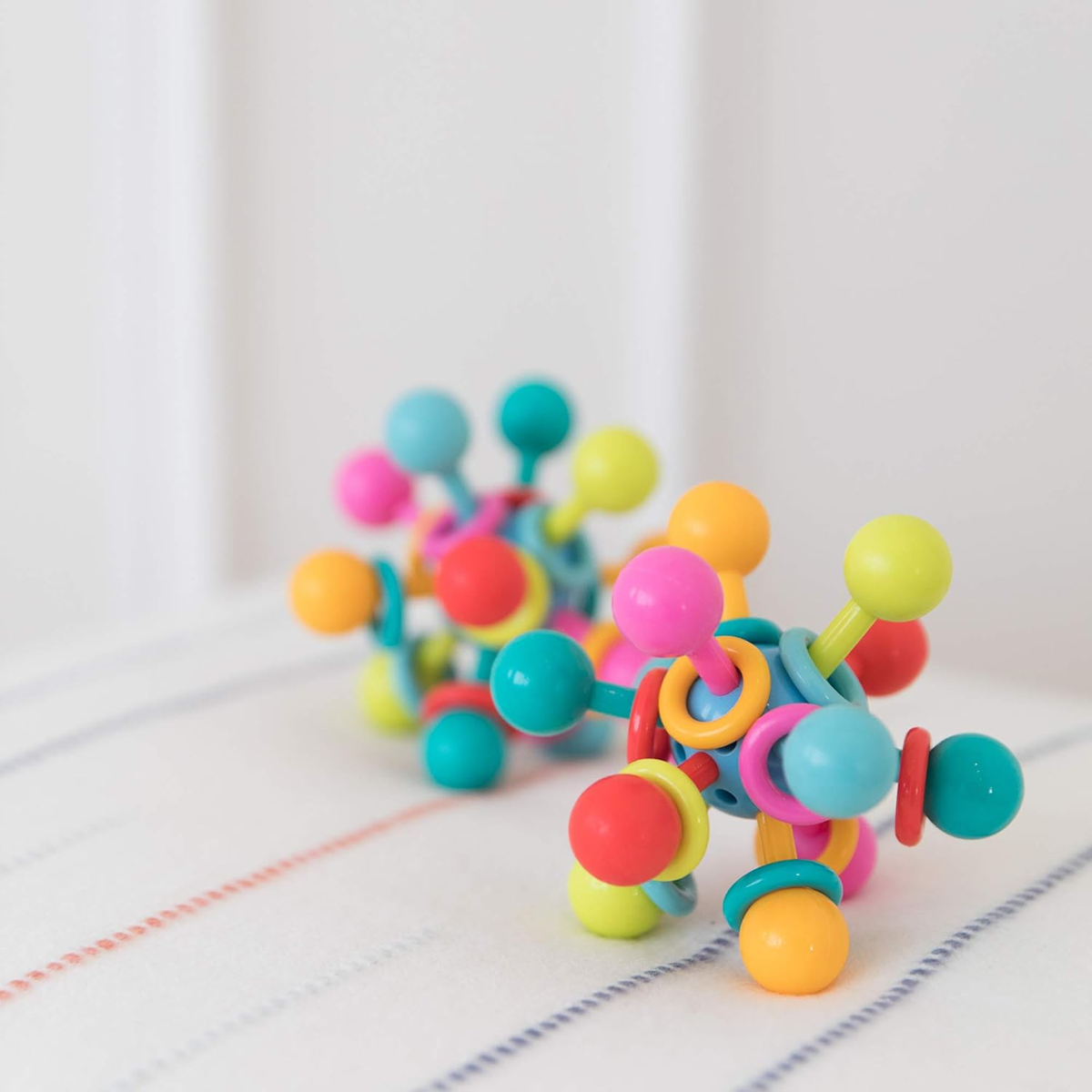 MANHATTAN TOY jucărie senzorială de dentiție cu zornăitoare și mărgele 8 x 8 cm