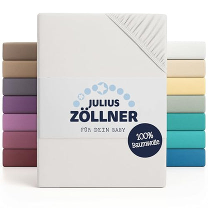 Opakowanie prześcieradła Julius Zöllner z oznaczeniem 100% bawełny na tle tkanin w różnych kolorach.