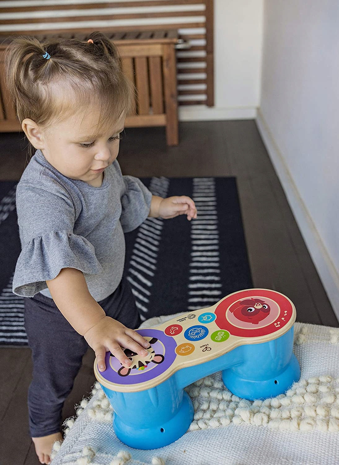 Dziecko dotykające pól drewnianego bongo Hape Baby Einstein Magic Touch.